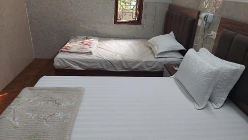 2 camas individuais num pequeno quarto com em Nhà nghỉ sao mai 2 em Hanói