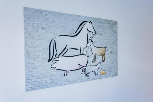 a drawing of a horse and sheep on a brick wall at Ferienhof Hofer in Absberg