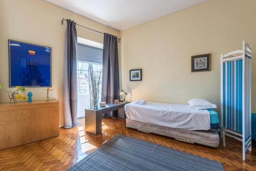 een slaapkamer met een bed en een groot raam bij GuestReady - Minimalistic studio downtown in Porto