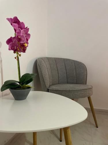 a chair and a white table with a flower on it at Villa Flora in Afantou
