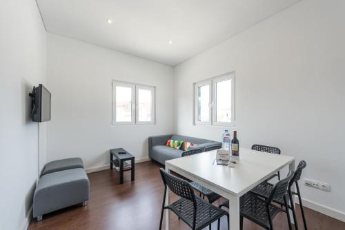 a living room with a table and chairs and a couch at GuestReady - Spacious modern stay in Porto in Vila Nova de Gaia