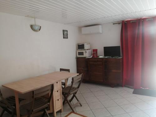 een keuken met een tafel en stoelen en een magnetron bij Appartement 2 pièces, équipé avec clim et parking. in Béziers