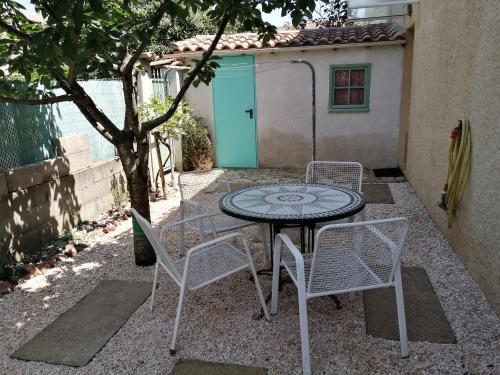 een terrastafel en stoelen voor een gebouw bij Appartement 2 pièces, équipé avec clim et parking. in Béziers
