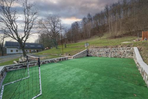 a tennis court with a net on a green field at Chata Hermann - Vernířovice in Vernířovice