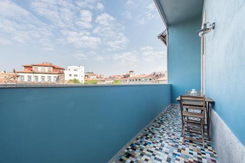 ポルトにあるGuestReady - Estadia moderna no centro do Portoの青い壁の客室で、テーブルと窓が備わります。