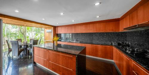 a kitchen with wooden cabinets and a black counter top at Luxury 4 pool Seaview 6 bedroom Villa on Surin Hill in Surin Beach