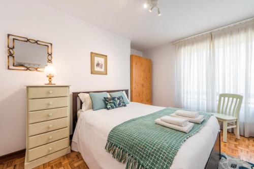 ein Schlafzimmer mit einem Bett, einer Kommode und einem Fenster in der Unterkunft GuestReady - Eclectic haven in the heart of Porto in Porto