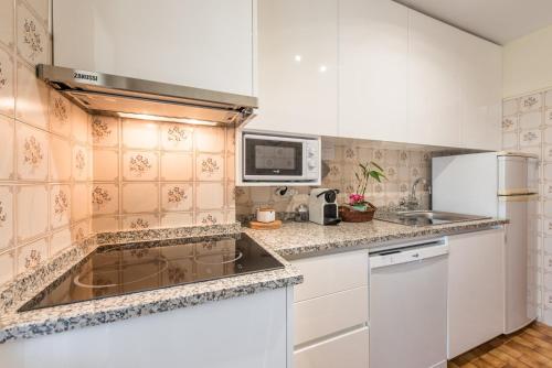 eine Küche mit einer Spüle und einer Mikrowelle in der Unterkunft GuestReady - Eclectic haven in the heart of Porto in Porto