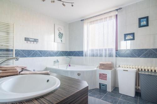 een witte badkamer met een bad en een wastafel bij Apartmán U nás doma in Břeclav
