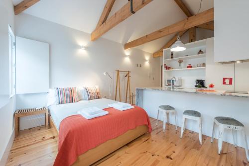 a bedroom with a bed and two stools at GuestReady - Chic city nest in Porto in Porto