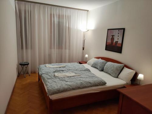ein Schlafzimmer mit einem großen Bett in einem Zimmer in der Unterkunft Júlia Apartman Kaposvár*** in Kaposvár