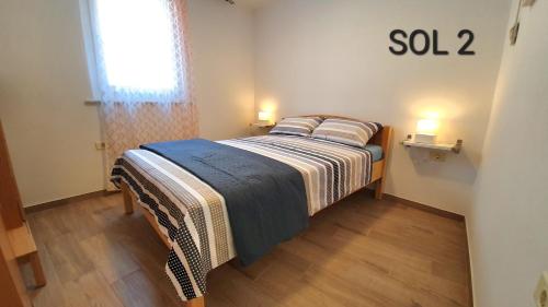 a small bedroom with a bed with two pillows at Apartments SOL in Izola