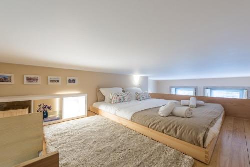 1 dormitorio con 1 cama grande con marco de madera en GuestReady - Lofted getaway in downtown Porto en Oporto