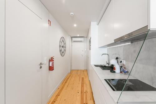 a kitchen with white counters and a wooden floor at GuestReady - Private oasis for two in Porto