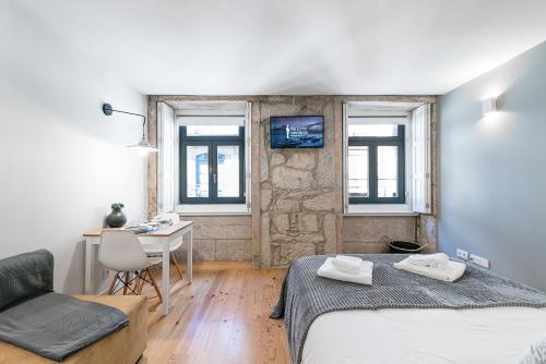 a bedroom with a bed and a desk and a table at GuestReady - Private oasis for two in Porto