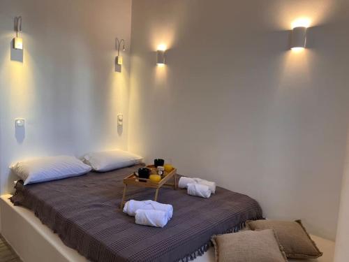 a bed with two pillows and a table on it at “Myrto” Apartments- Ornos Beach in Mýkonos City