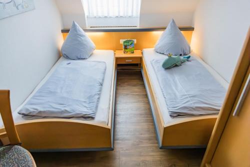 two beds in a small room with a desk at Ferienhof Hofer in Absberg