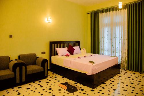a bedroom with a bed with a chair and a window at My Resort Yala in Tissamaharama