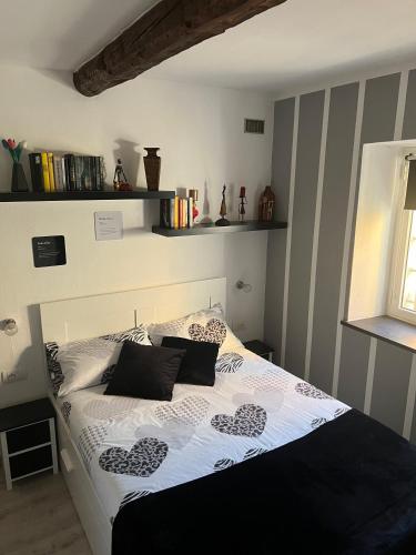 a bed with black and white sheets and pillows at A.R.L.A. House in Cogorno