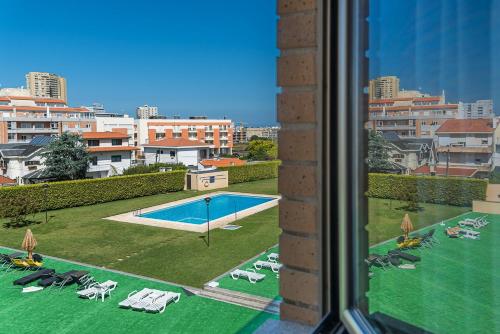 a view of a swimming pool from a window at GuestReady - Luxe living by the pool in Póvoa de Varzim