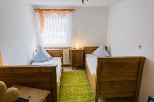two beds in a small room with a window at Ferienhof Hofer in Absberg