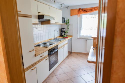 a kitchen with white cabinets and a stove top oven at Ferienhof Hofer in Absberg