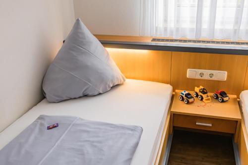 a bed with a large pillow and a desk at Ferienhof Hofer in Absberg