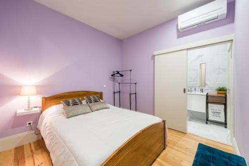 ein Schlafzimmer mit lila Wänden und einem großen Bett in der Unterkunft GuestReady - Seaside getaway in Porto in Porto