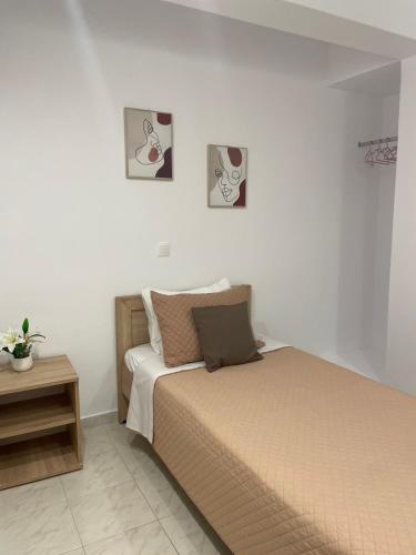 a bedroom with a bed and two pictures on the wall at Villa Flora in Afantou