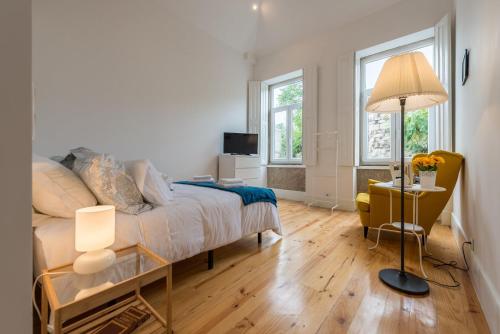 een slaapkamer met een bed en een tafel met een lamp bij GuestReady - Quaint comfort near Clérigos Tower in Porto