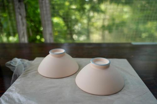 two white vases sitting on top of a table at ホテルコンドミニアム土花土花 in Onna