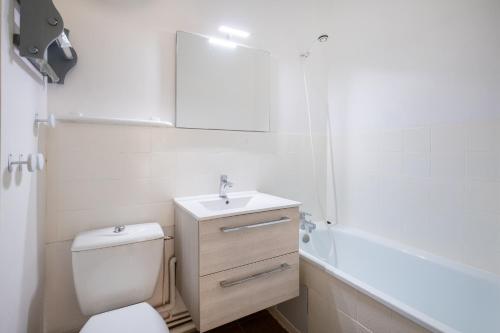 une salle de bain avec toilettes, lavabo et baignoire dans l'établissement AS9405- P2 Centre ville- clim et garage, au Grau-du-Roi