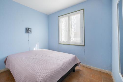 une chambre bleue avec un lit et une fenêtre dans l'établissement AS9405- P2 Centre ville- clim et garage, au Grau-du-Roi