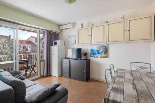 un salon avec une table de salle à manger et une cuisine dans l'établissement AS9405- P2 Centre ville- clim et garage, au Grau-du-Roi