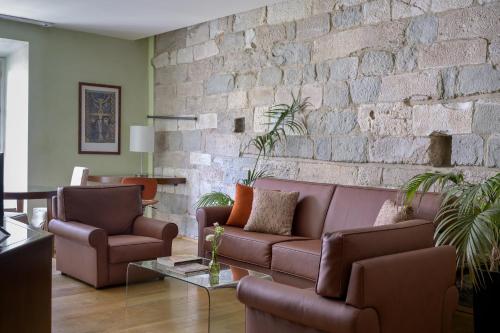 a living room with a couch and a brick wall at Hotel Ilaria in Lucca