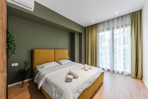 um quarto com uma cama grande e chinelos em Modern Central Apartment em Durrës