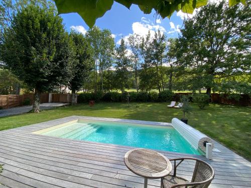 - une piscine avec 2 chaises sur une terrasse en bois dans l'établissement Villa avec piscine 3 chambres, à Foix