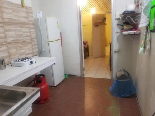 a kitchen with a refrigerator and a sink and a counter at Alicia's lodge in Port-of-Spain