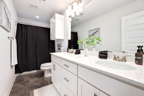 a white bathroom with a sink and a toilet at The Oakley - Near Lake Fayetteville in Fayetteville
