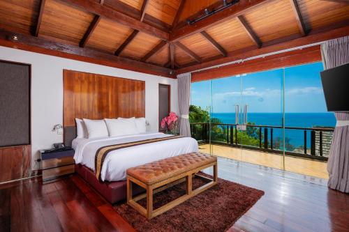 a bedroom with a bed and a view of the ocean at Luxury 4 pool Seaview 6 bedroom Villa on Surin Hill in Surin Beach