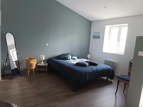 una camera da letto con un letto con pareti blu e una finestra di Jolie Maison au centre du village a Gruissan