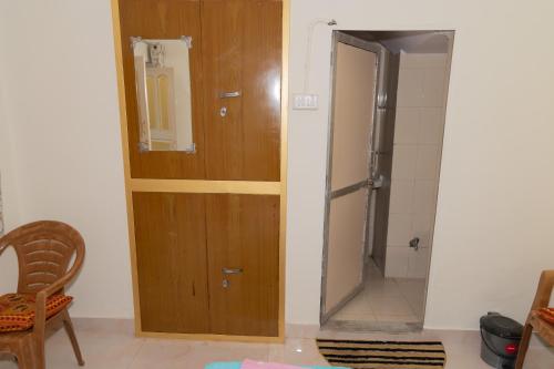 a bathroom with a wooden door and a shower at Homestay Urmil Basant in Jaipur