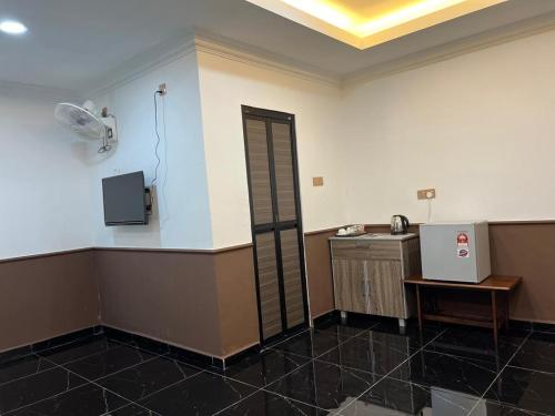 Zimmer mit einer Küche mit einem Ventilator und einem Waschbecken in der Unterkunft The Lodge in Kuala Kerai