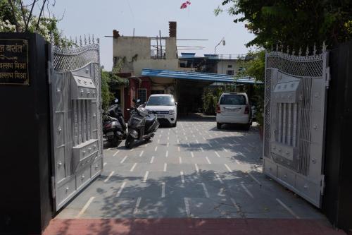 an open gate with cars parked on a street at Homestay Urmil Basant in Jaipur