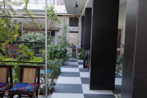 a courtyard with a checkered floor and plants at Homestay Urmil Basant in Jaipur