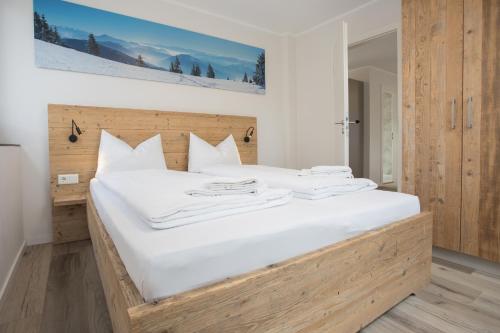 - une chambre avec un grand lit blanc et une tête de lit en bois dans l'établissement Appartement - Winterbergerstrasse 3 - Winterberg-Neuastenberg, à Winterberg