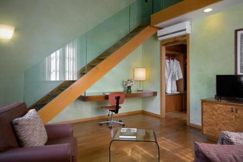 a living room with a staircase and a chair at Hotel Ilaria in Lucca