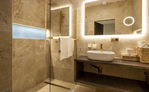 a bathroom with a sink and a mirror at Apartamenty WRZOS w Perłowej Przystani in Sianozety
