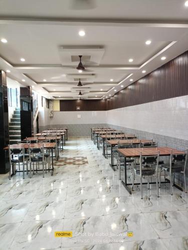 a banquet hall with tables and chairs on a tile floor at Hotel Samiksha Inn in Ayodhya
