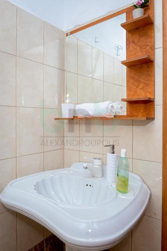 a bathroom with a white sink and a mirror at Dikella Beach 3 BDR Summer House in Mesimvría